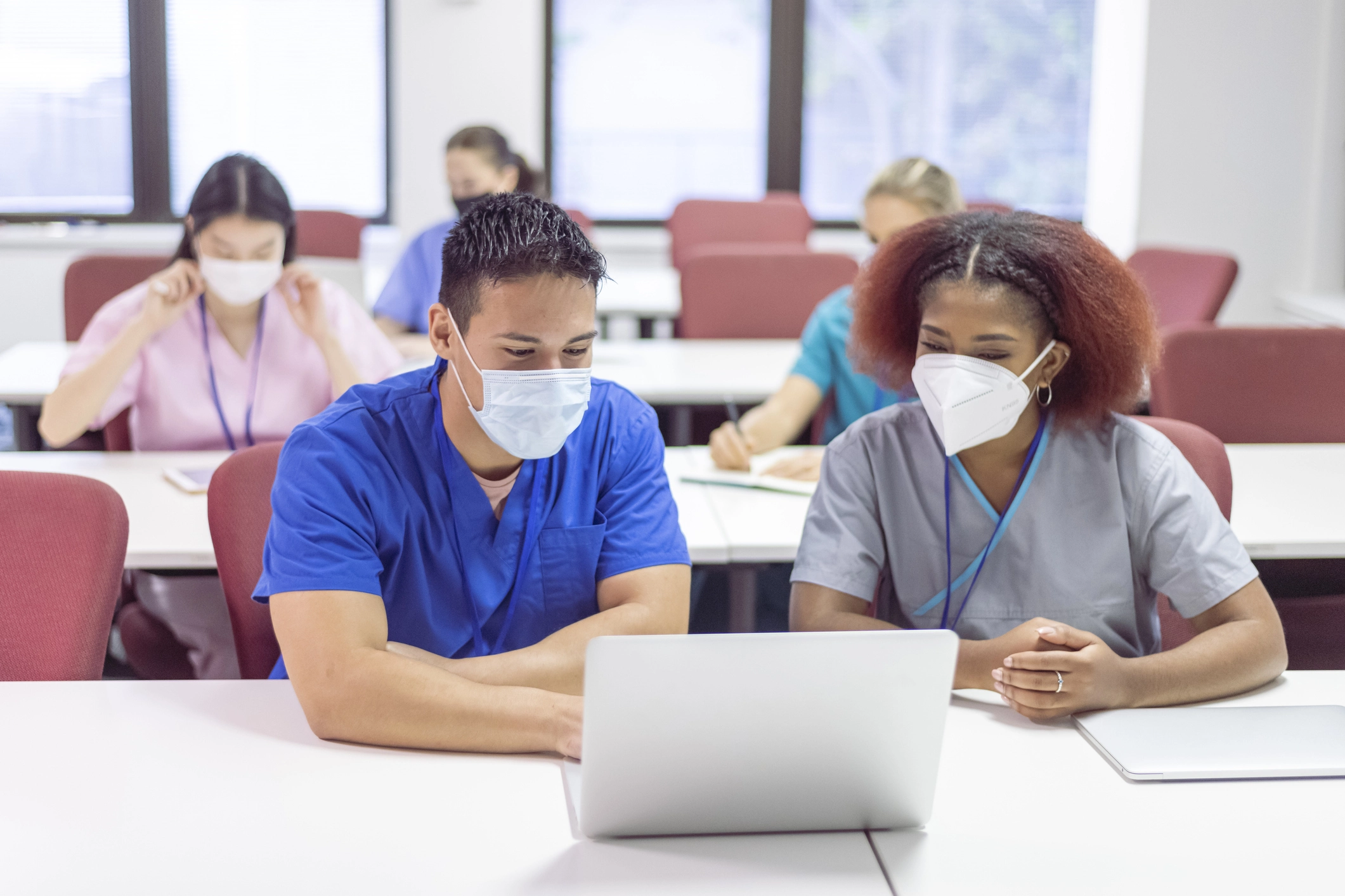 A group of masked providers learn together in a classroom