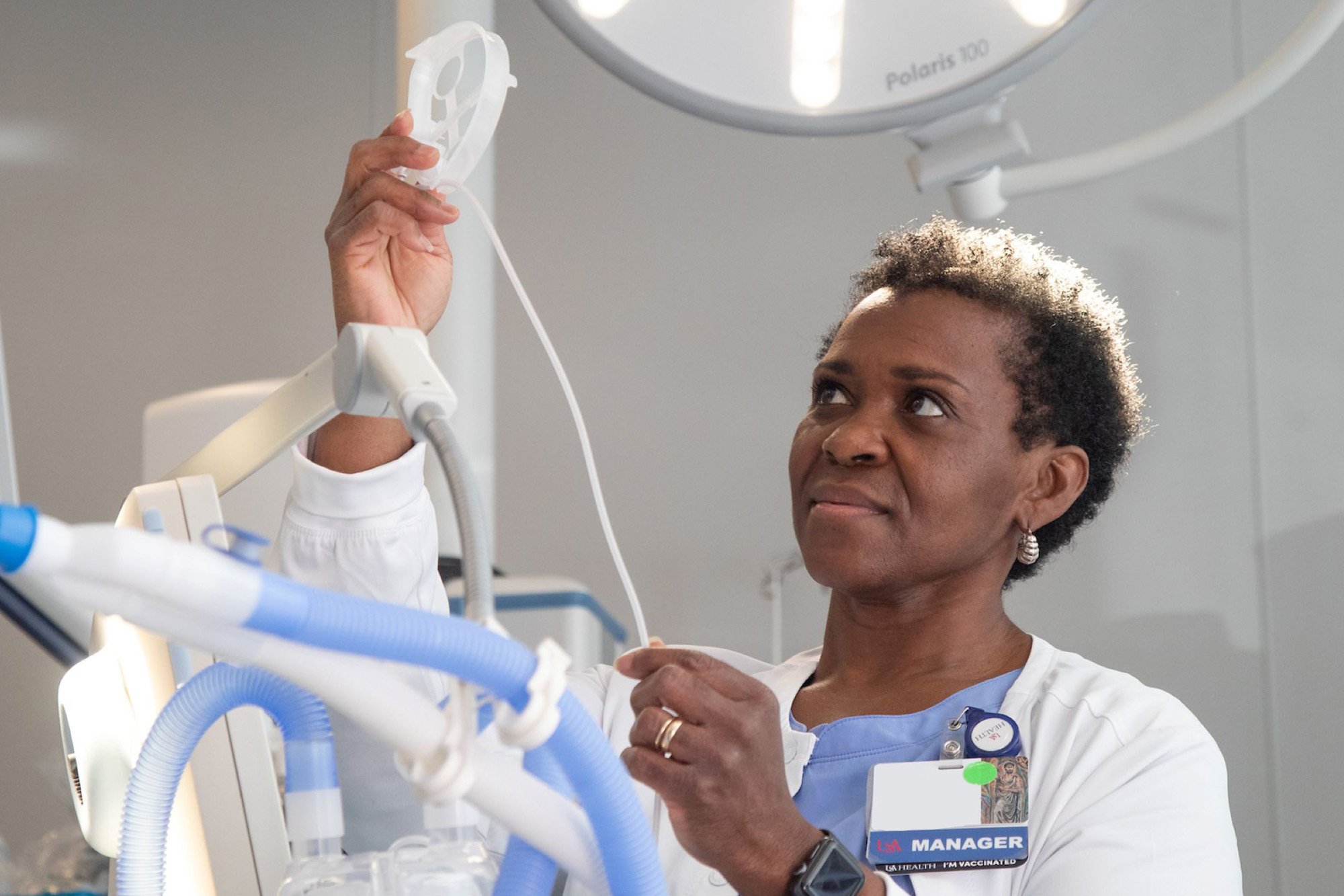 A group of medical professionals wearing scrubs in front of a window.